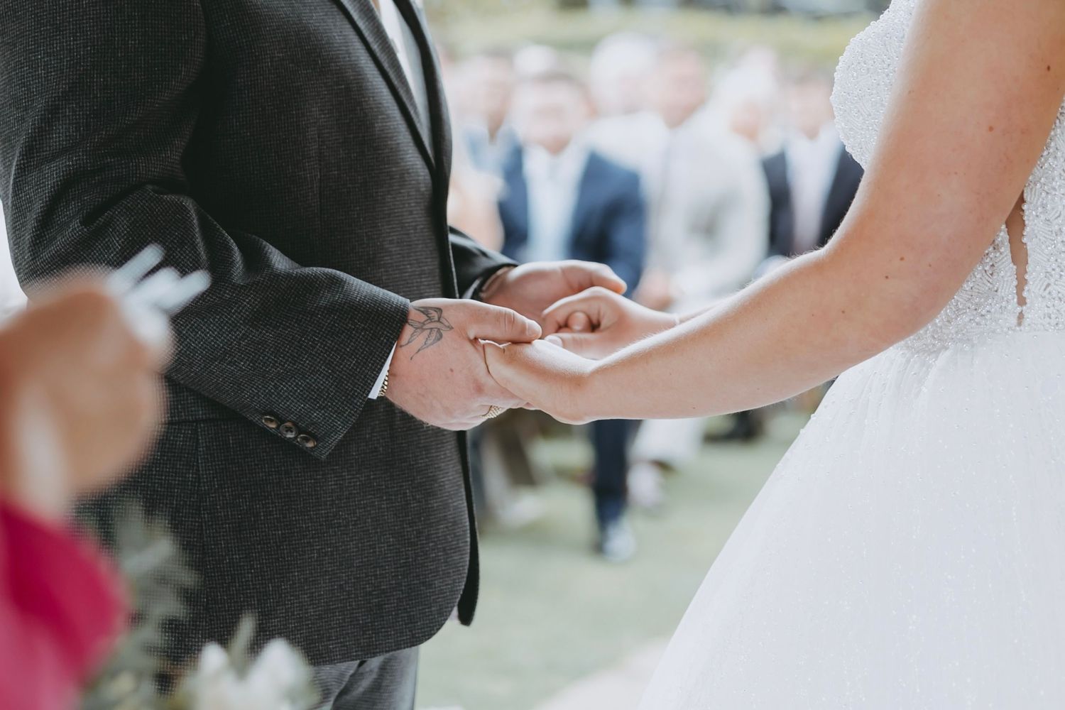 A couple shares an intimate moment during their first dance at an outdoor wedding reception.