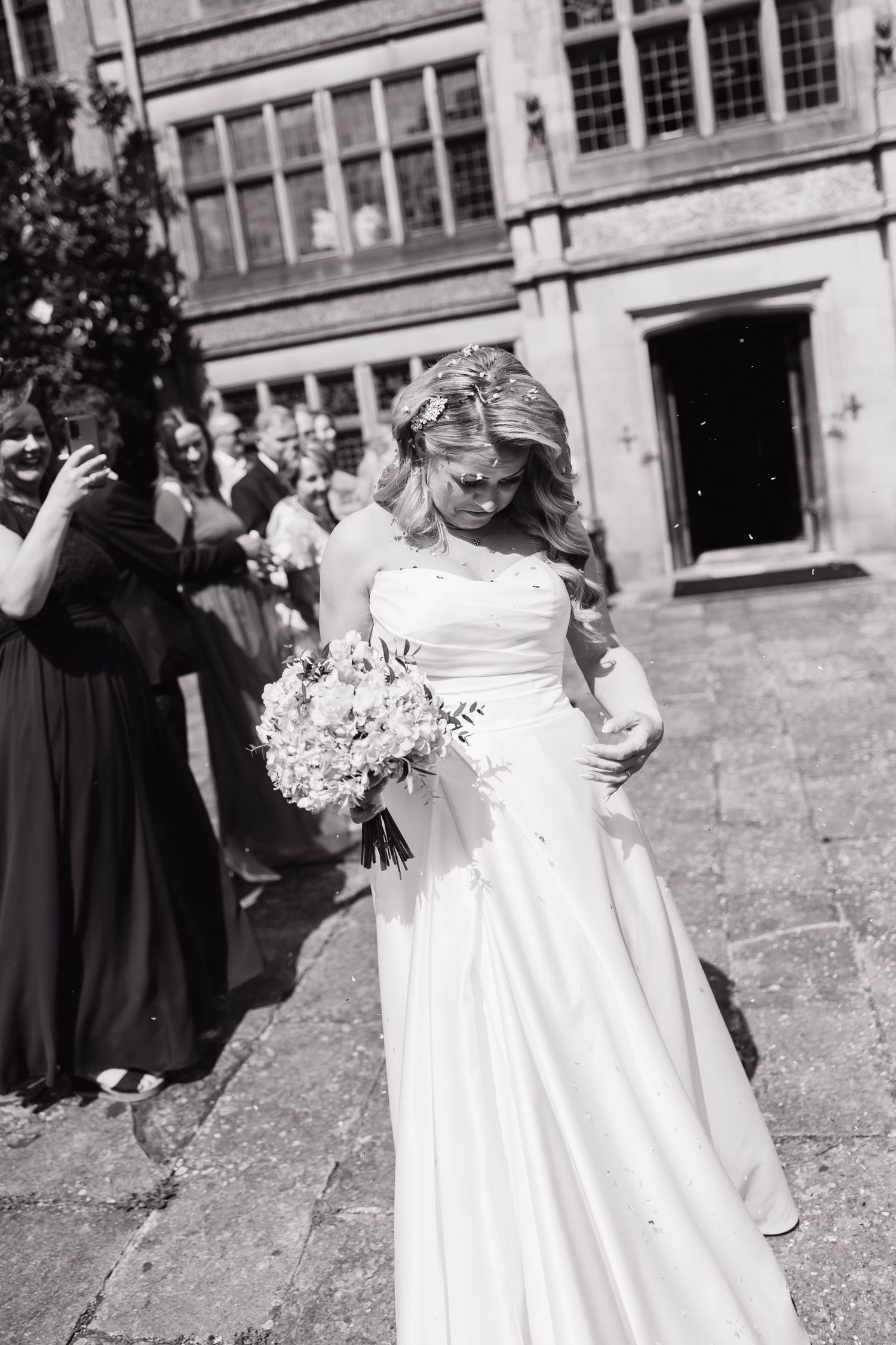 Black and white photo of wedding celebration on stone courtyard.