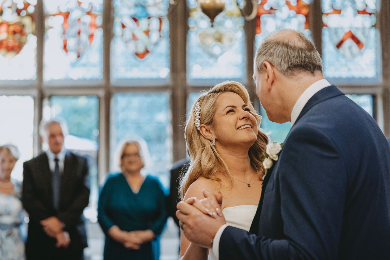A joyful dance moment captured in a room with beautiful stained glass windows.