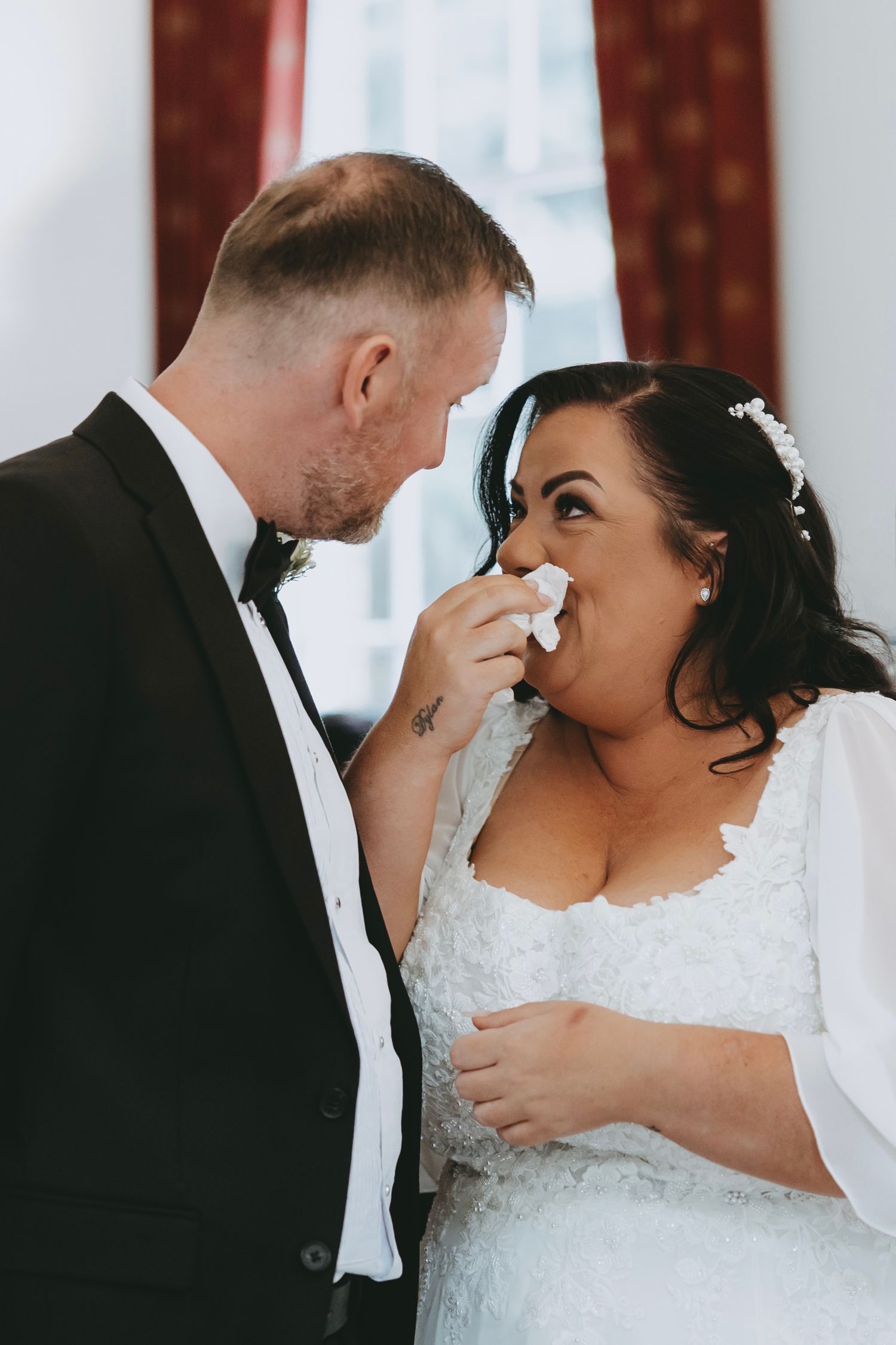 A tender moment between newlyweds as they share a laugh during their wedding ceremony.