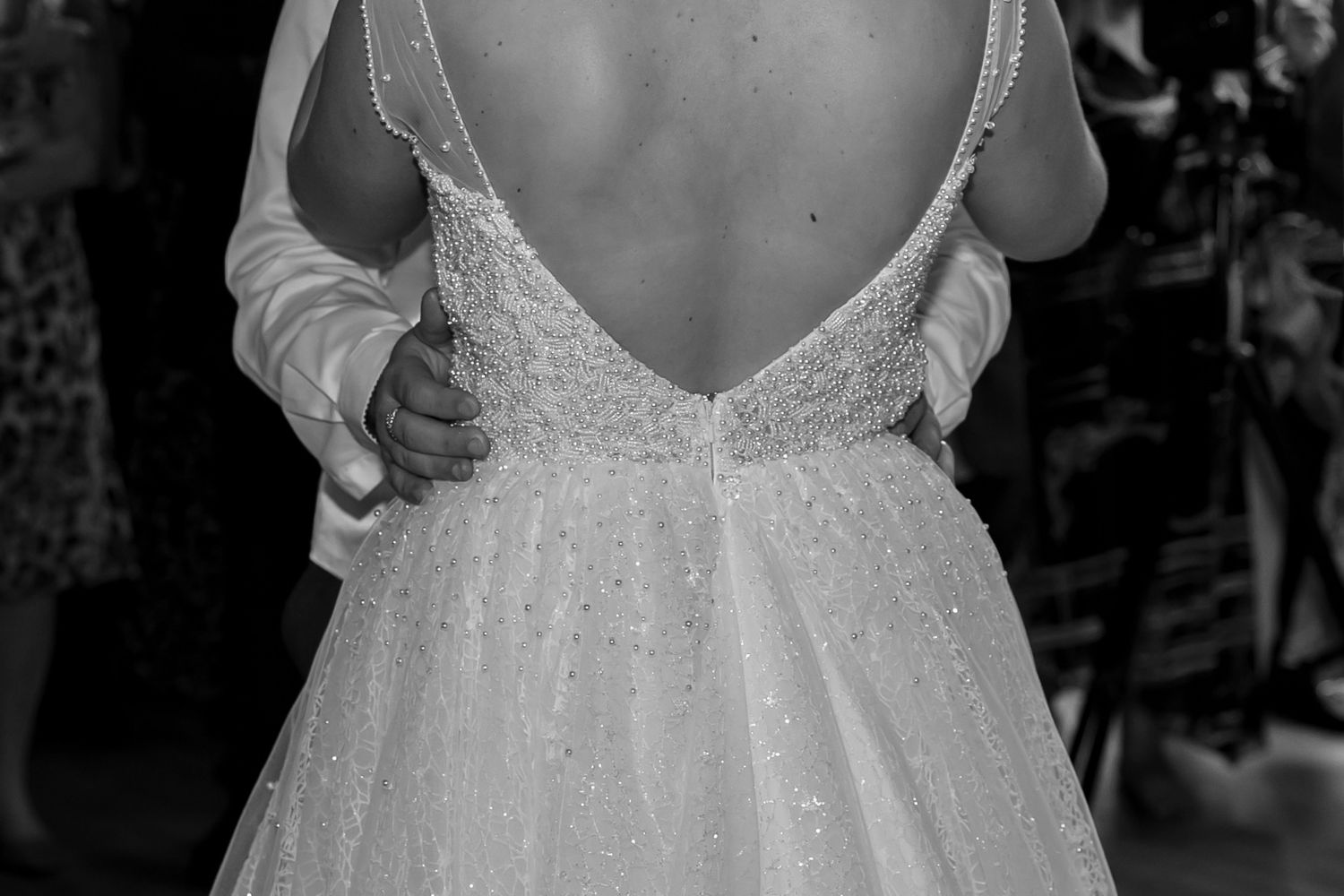 Close-up detail of a bride's lace wedding dress back with intricate beading.