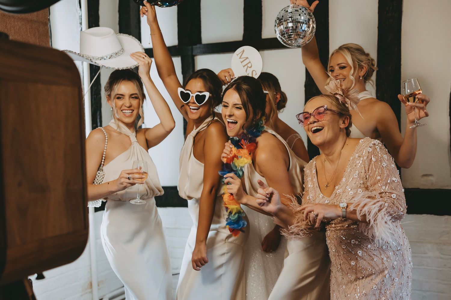 Wedding party members celebrate with champagne in an elegant indoor setting.