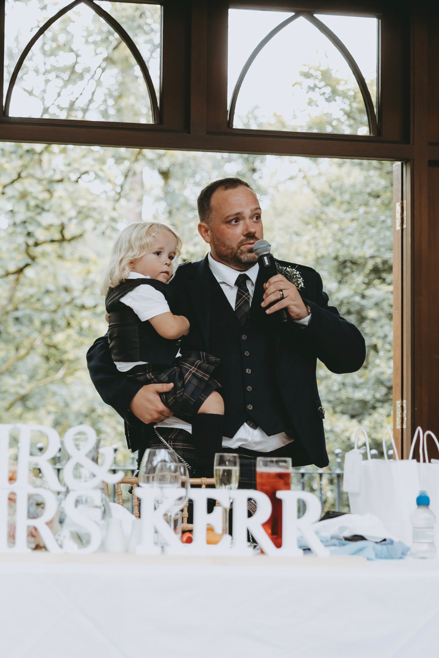 Wedding reception speech at head table with decorative 'Mr & Mrs' letters.