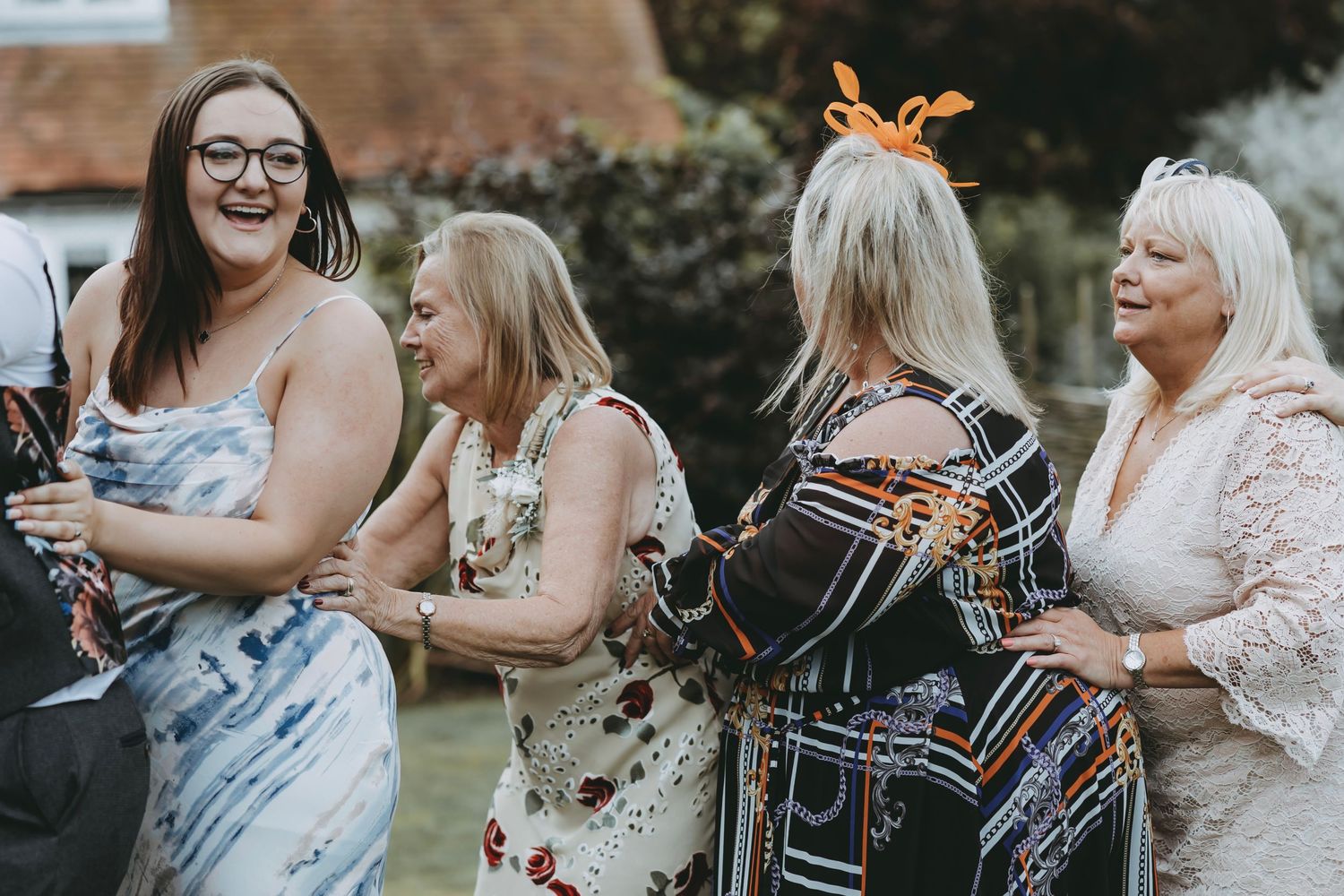 Wedding guests socialize and enjoy drinks during an outdoor garden reception.