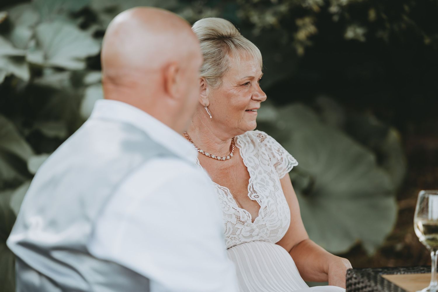 Guests seated at outdoor wedding reception tables during evening celebration.