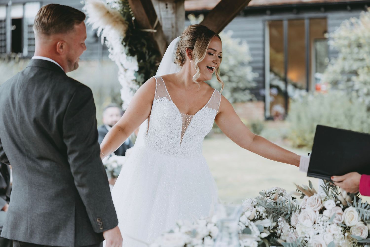 Bride in white dress celebrating at outdoor wedding reception.
