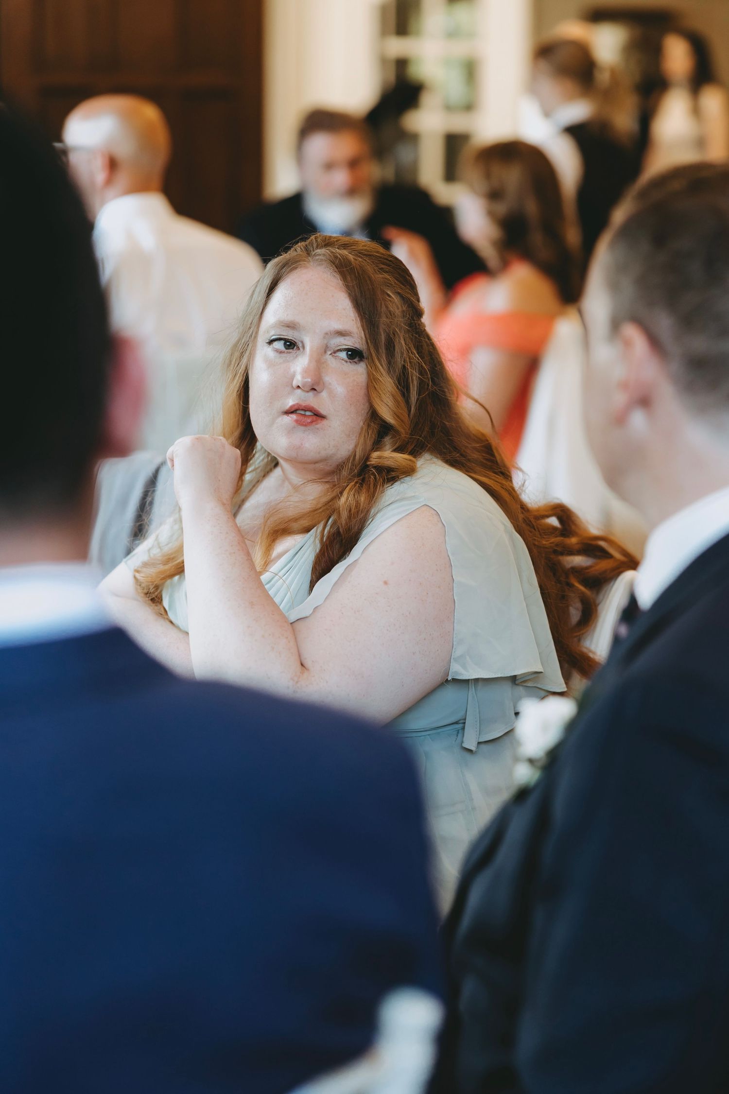Wedding guests engaged in conversation during an elegant indoor reception.