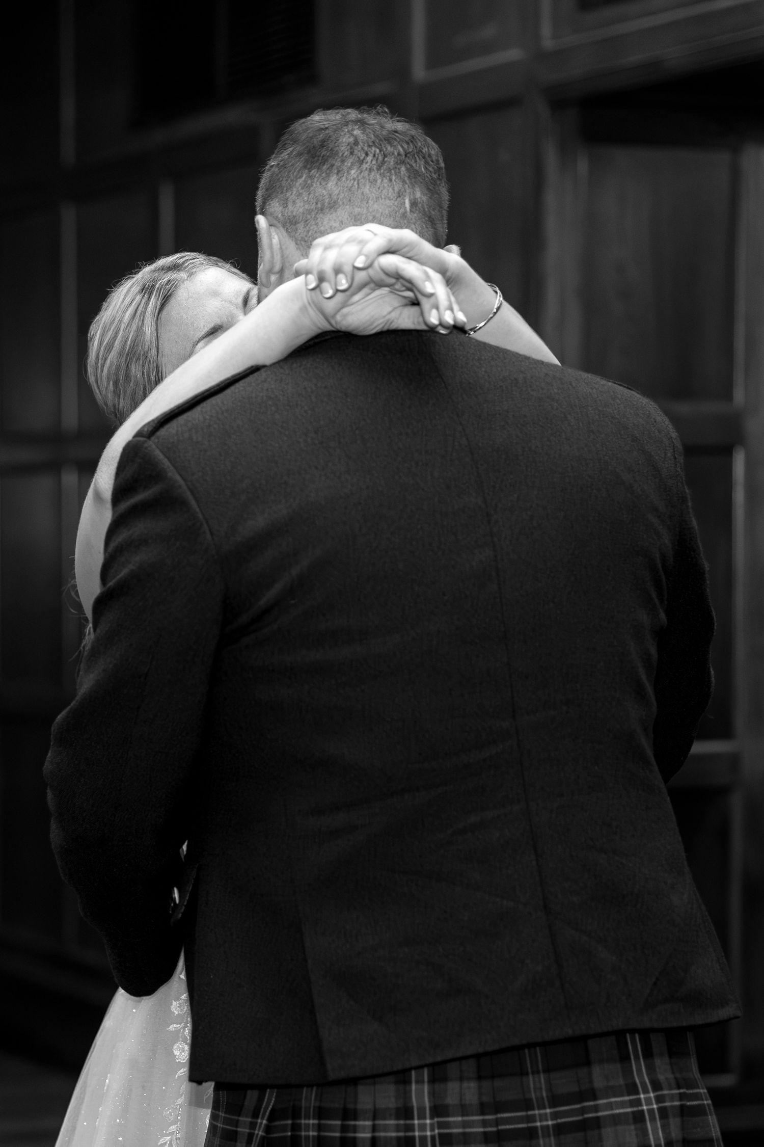 A romantic black and white photo of a couple embracing during their wedding dance.