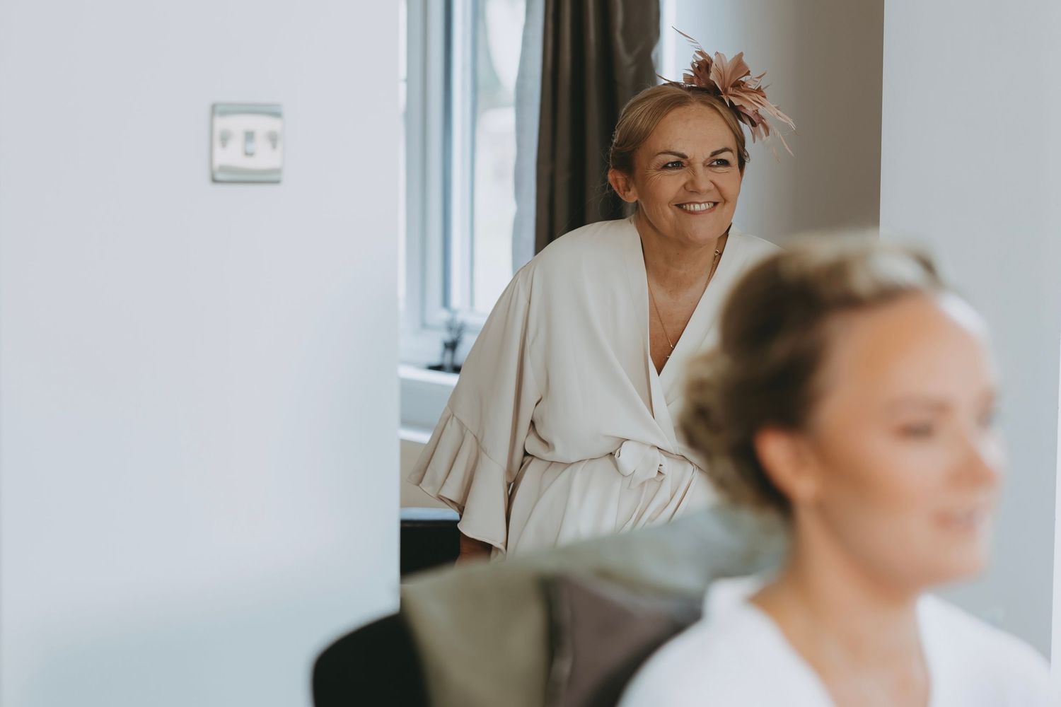 Wedding preparation scene with makeup artists working in elegant white robes.
