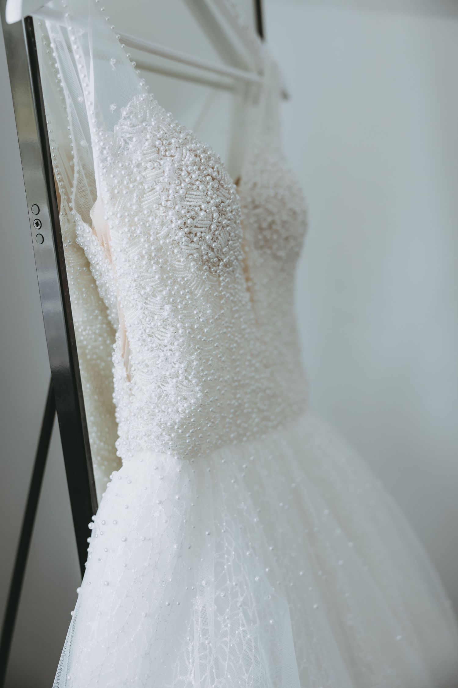 Detailed view of beaded bodice on an elegant white wedding gown.
