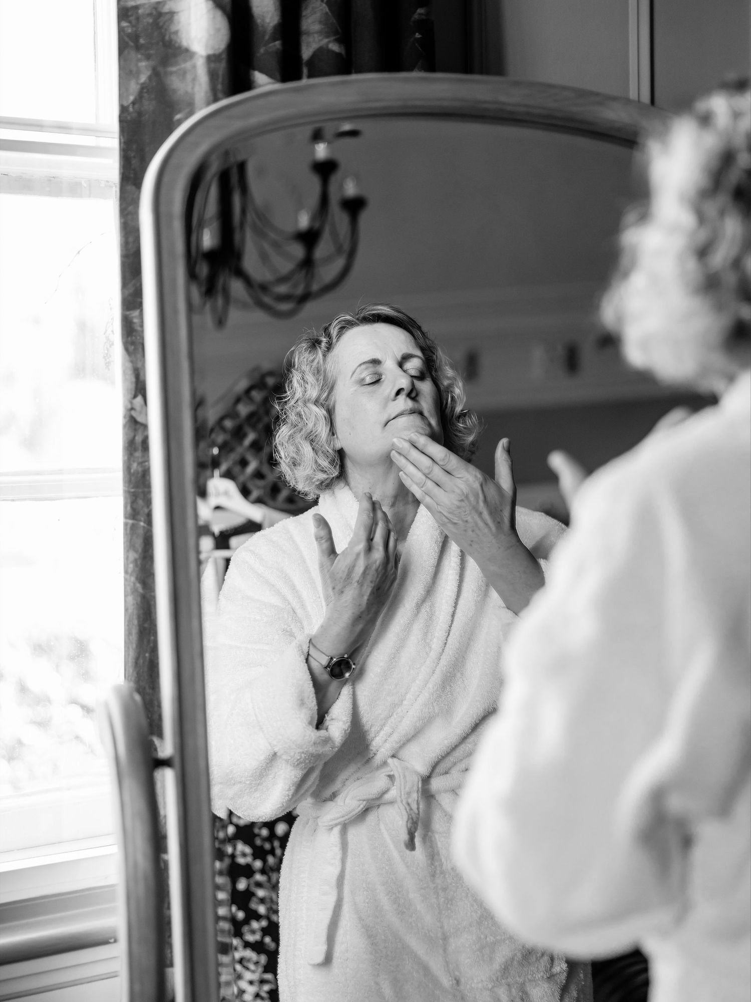 Black and white photos capturing intimate moments during a beauty preparation session.