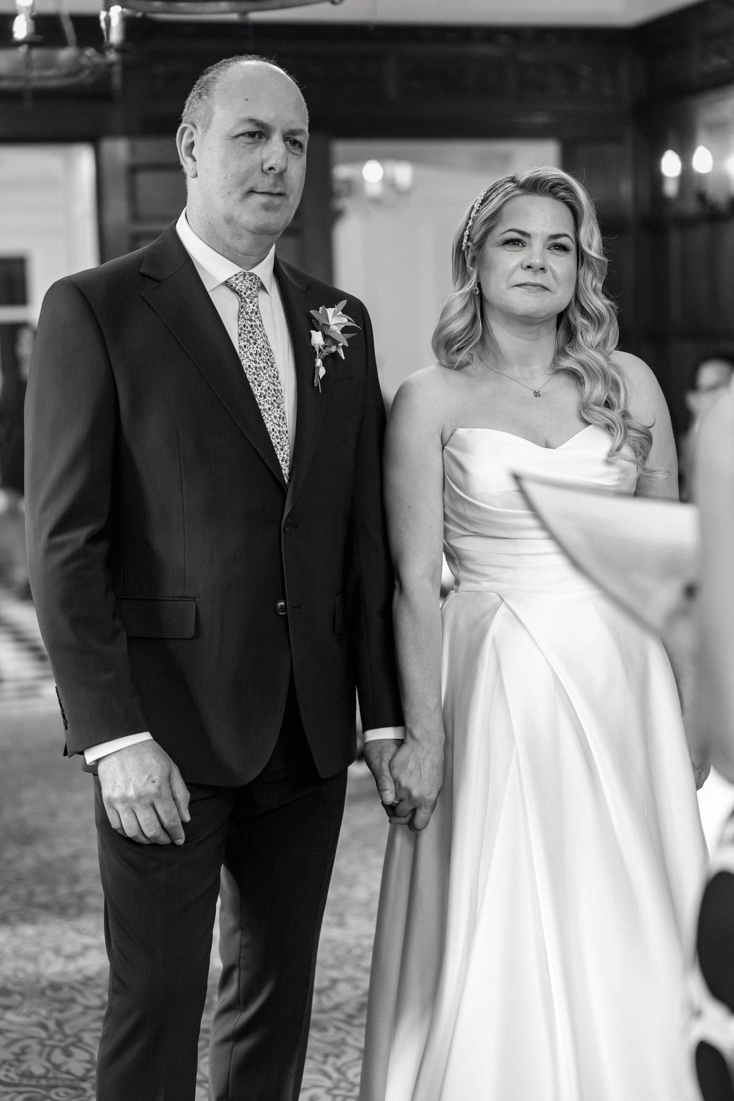 Black and white portrait of couple during wedding celebration in elegant indoor setting.