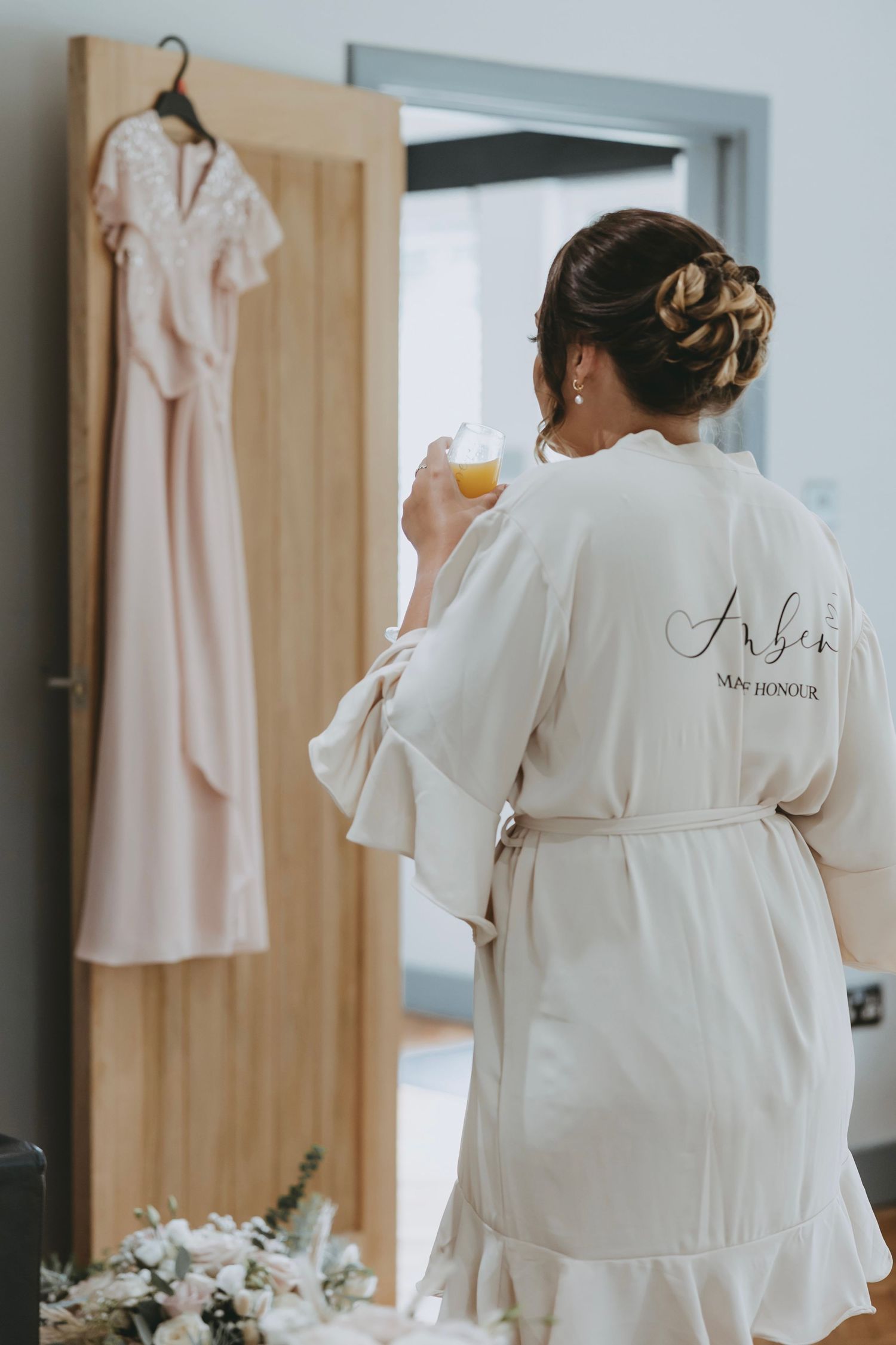 White monogrammed robes hanging in a dressing room during wedding preparations.
