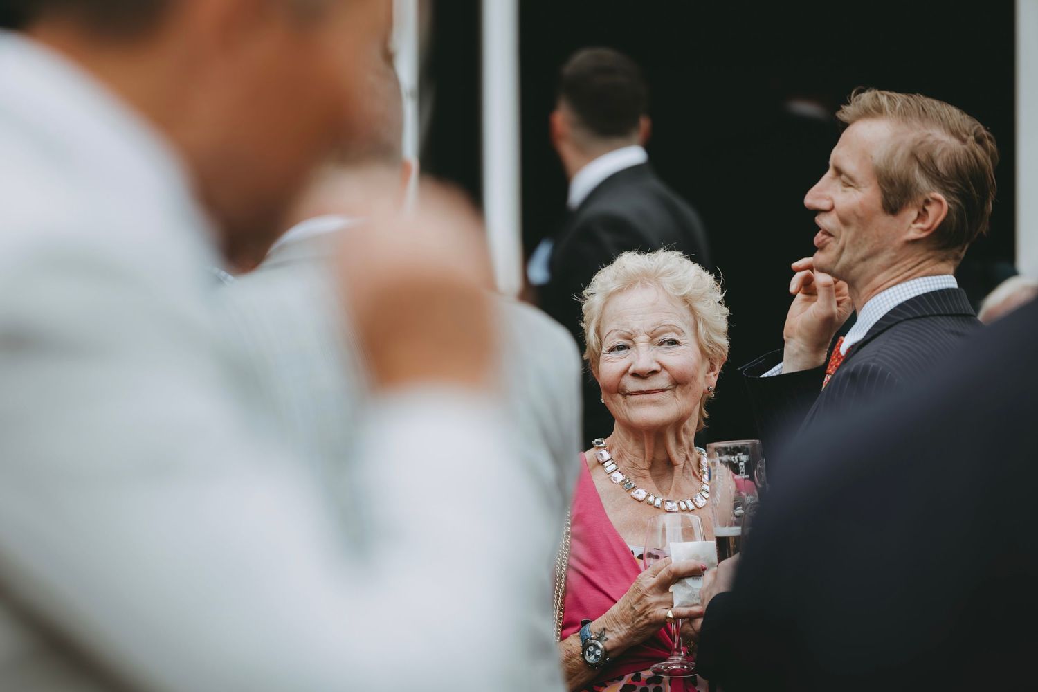 Wedding guests chat and enjoy drinks during an outdoor cocktail hour.