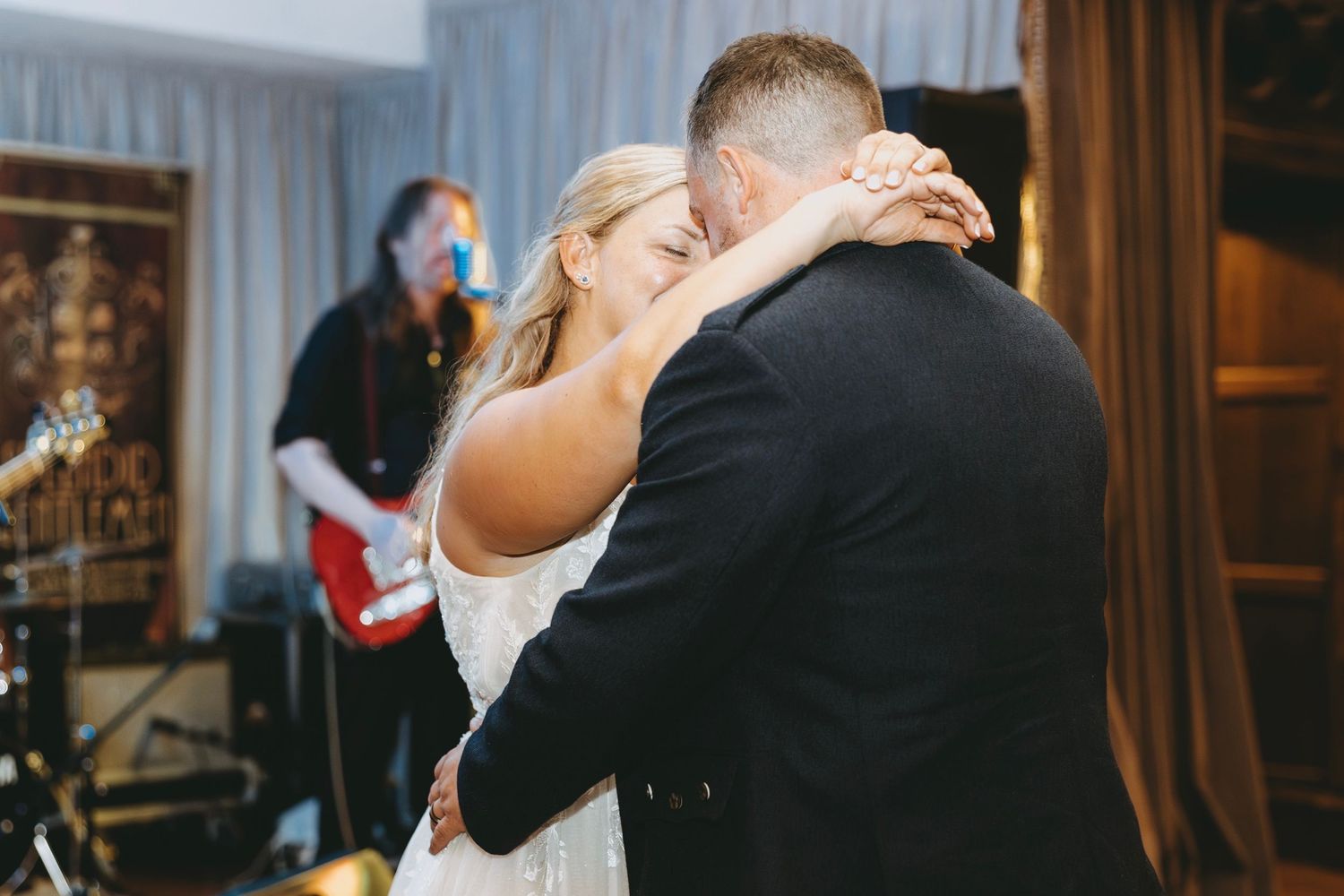 A couple shares an intimate dance moment at their wedding reception.