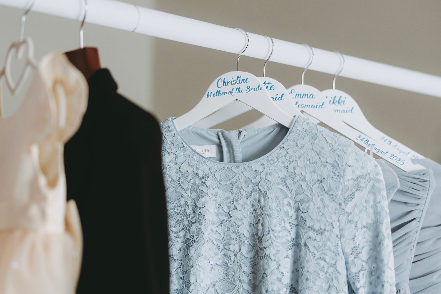 Row of light blue and white formal dresses displayed on hangers.