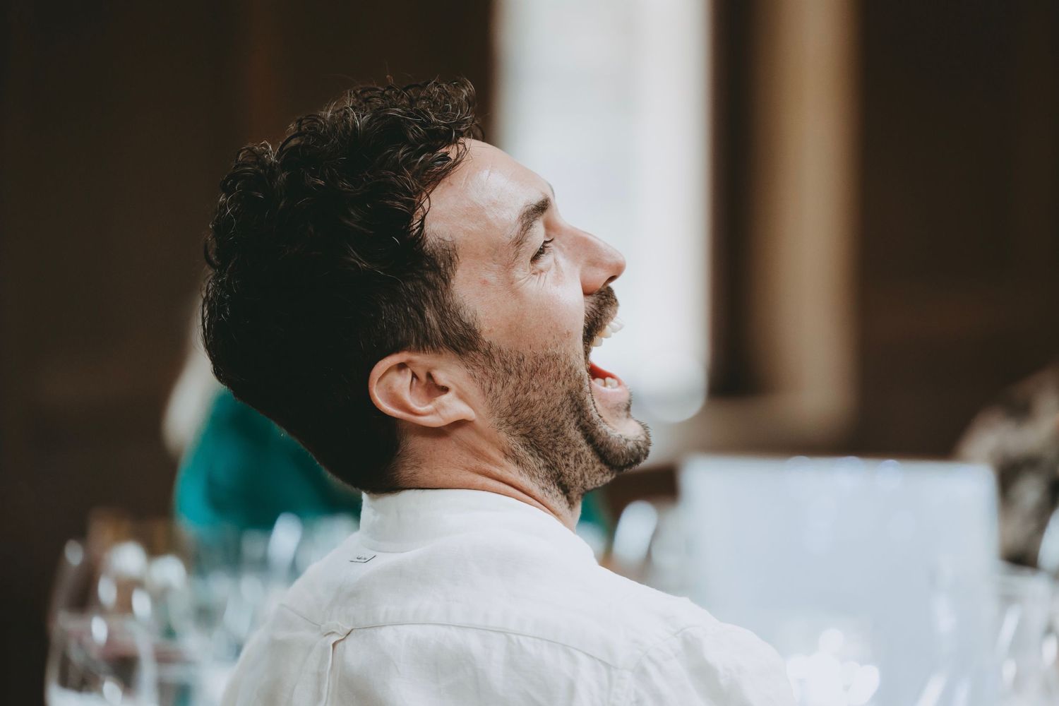 Side view of guests enjoying conversation at an elegant indoor reception.
