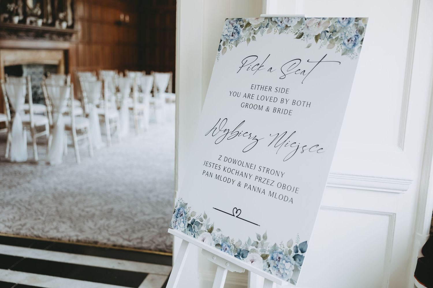 Elegant wedding signage with blue floral details displayed on white easels.