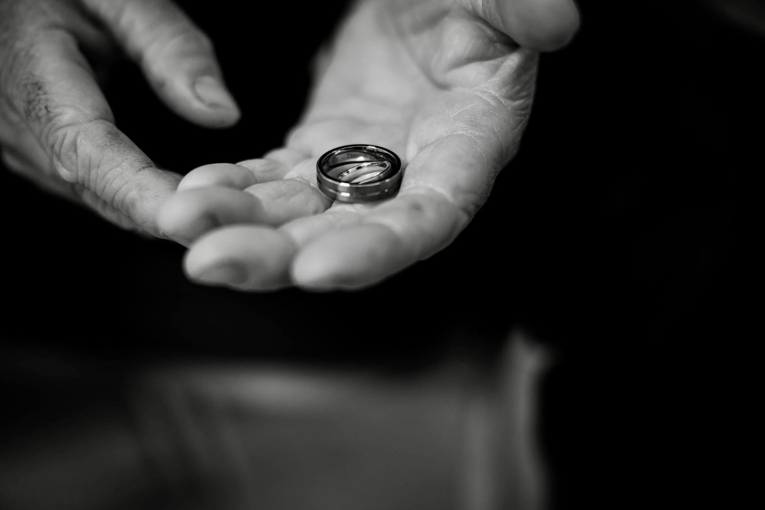 Black and white photo series showing hands holding a small compass in different positions.