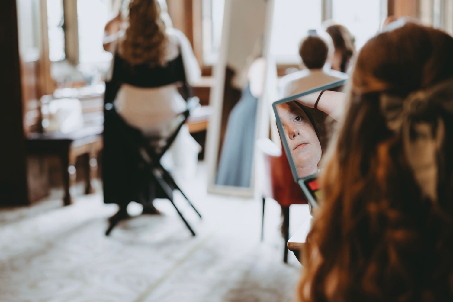 Blurred figures in a bright room with chairs prepare for a special event.