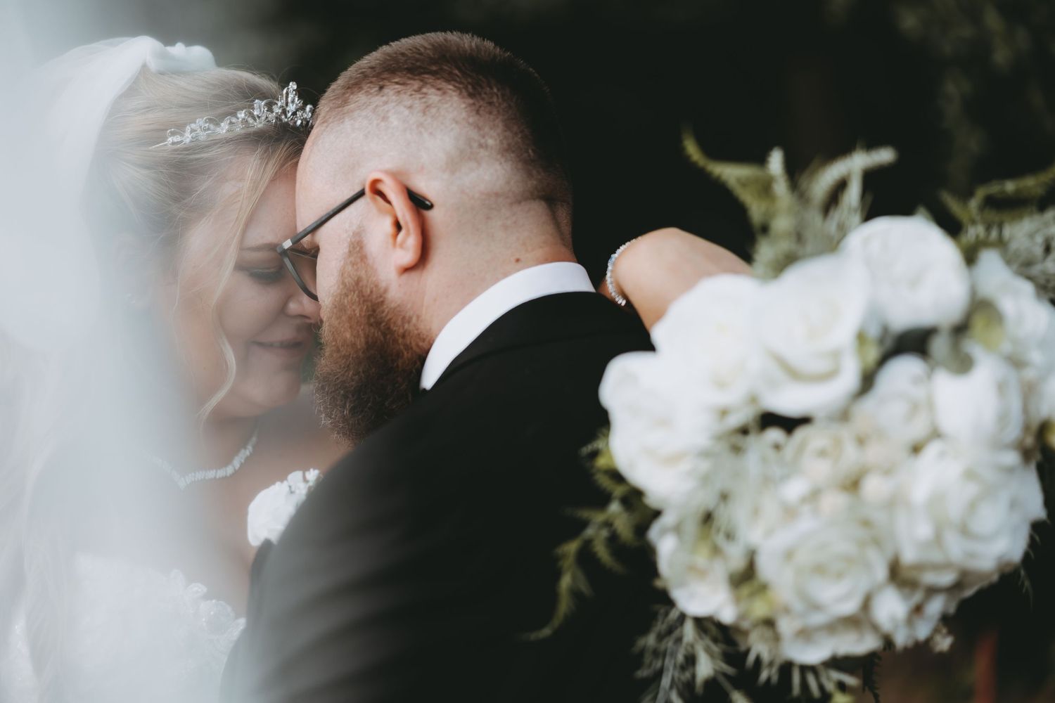 Close-up of white roses in a wedding bouquet with soft focus background.