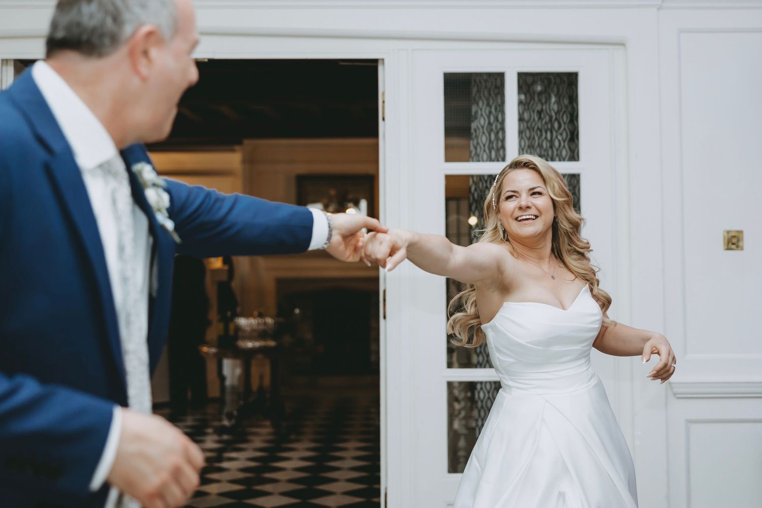 Elegant wedding reception with couples dancing on a black and white checkered floor.