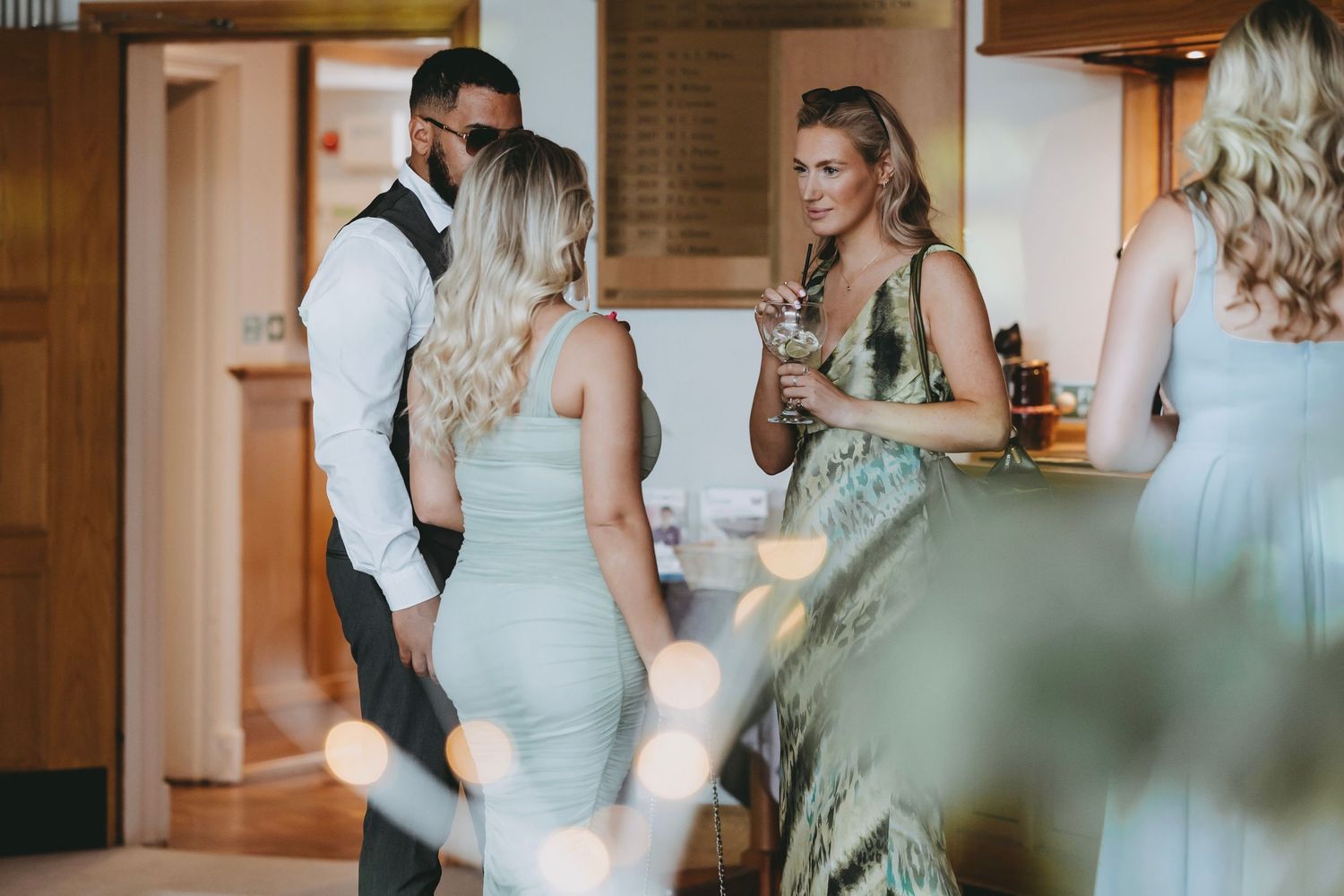 Wedding party gathered in rustic wood-paneled room during preparation.