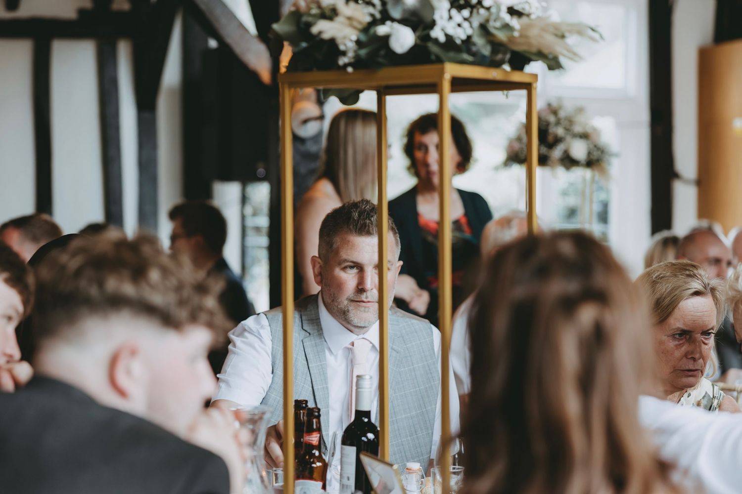 Elegant wedding reception venue with floral centerpieces and gold-framed decor.