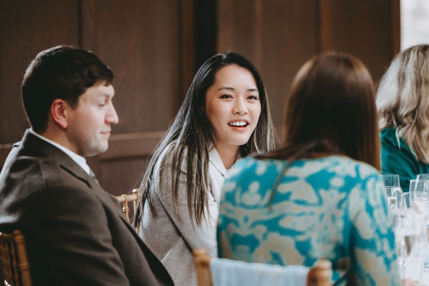 Wedding reception guests enjoying conversation at elegantly decorated tables with turquoise accents.