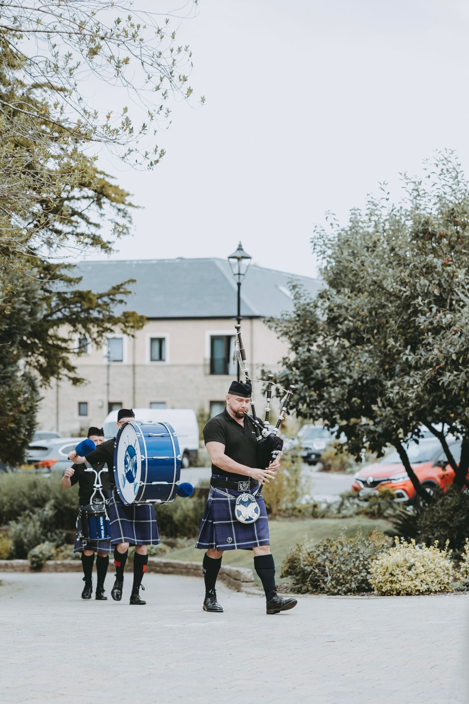 Bagpipers in traditional Scottish kilts performing at outdoor event.