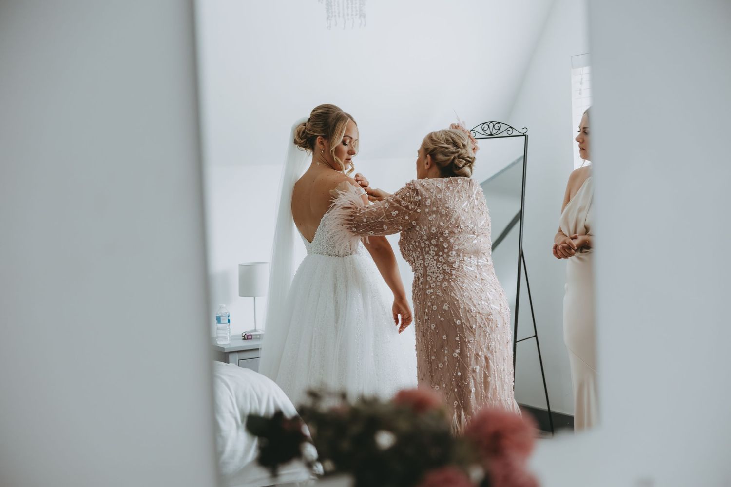 Final dress adjustments being made during intimate wedding preparation moment at the Warren Estate, Essex.