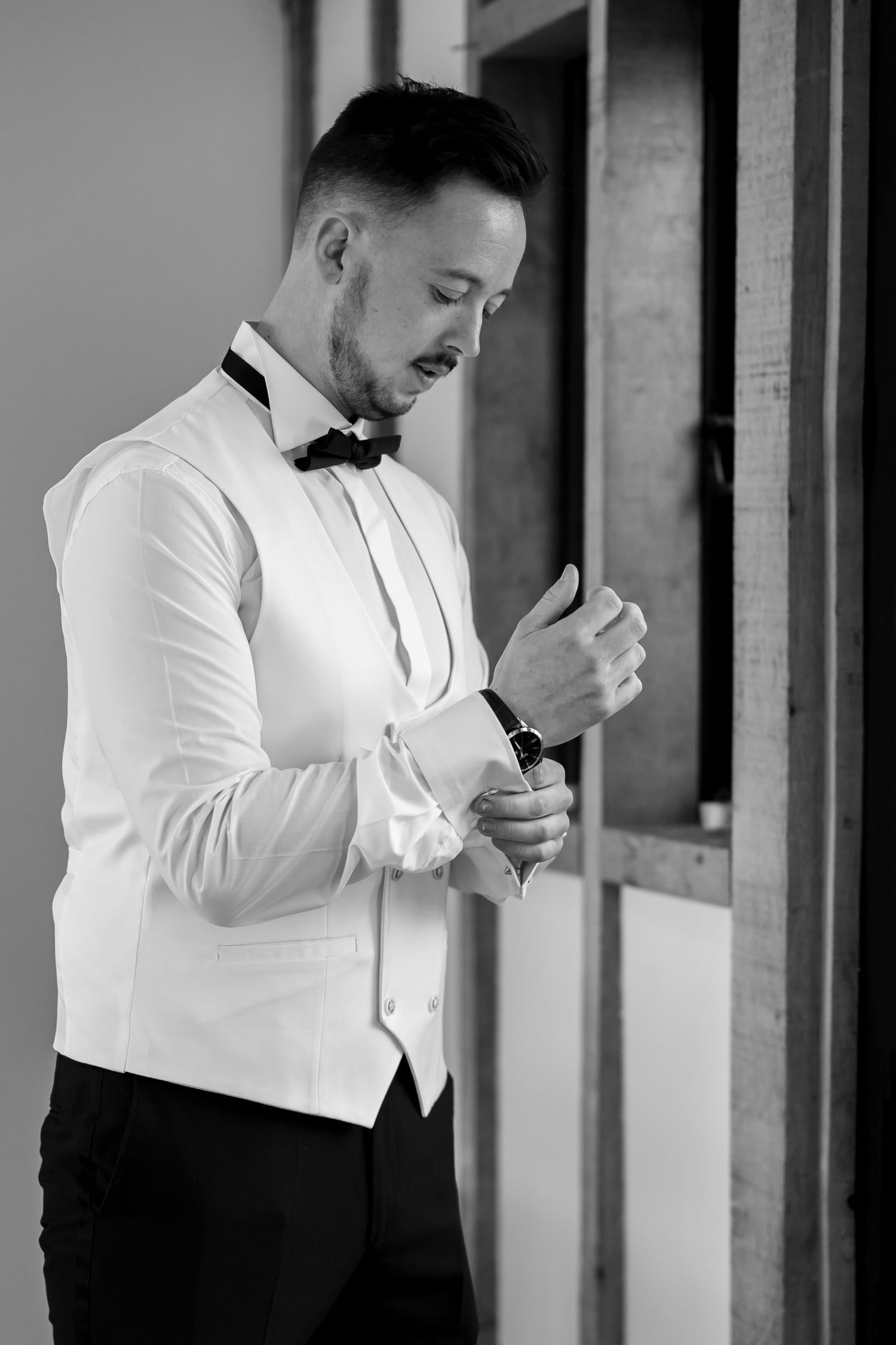 Black and white photo of formal attire preparation with bow tie and white shirt.