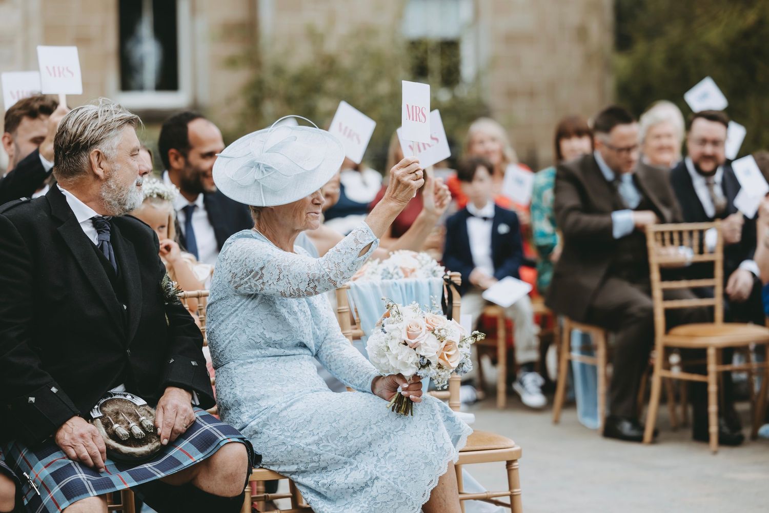 Wedding guests enjoy outdoor reception activities in formal attire.