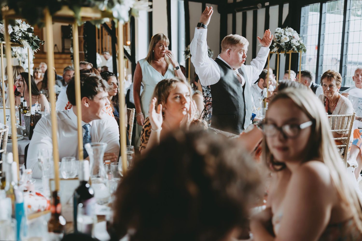 Wedding guests seated at long tables during reception celebrations.