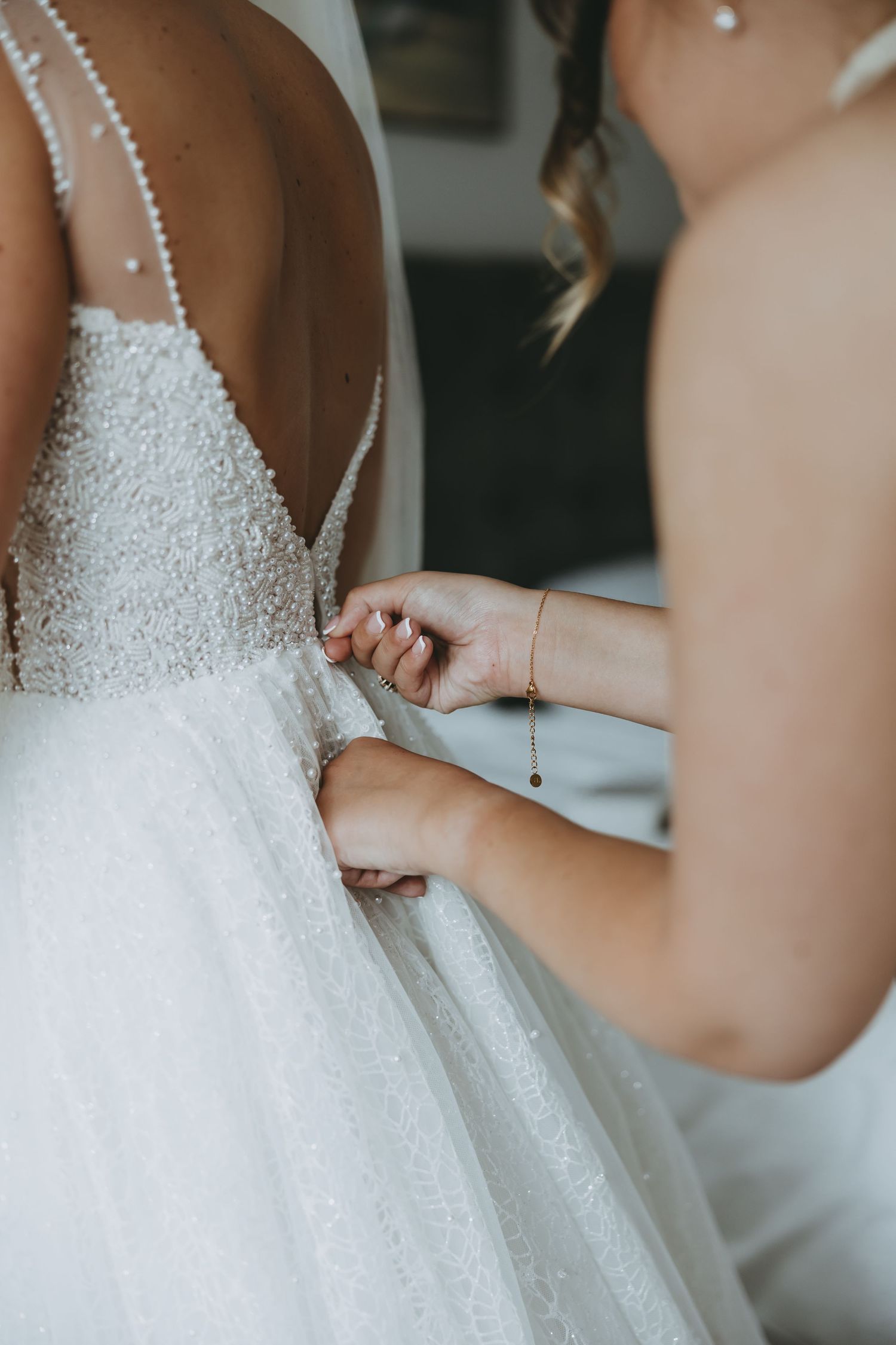 Detailed view of a beaded wedding dress bodice with pearl straps.