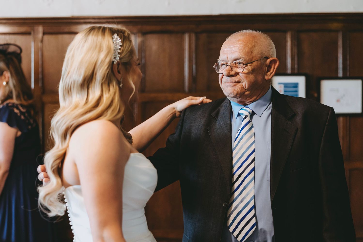 A touching embrace shared between wedding attendees in an elegant venue.