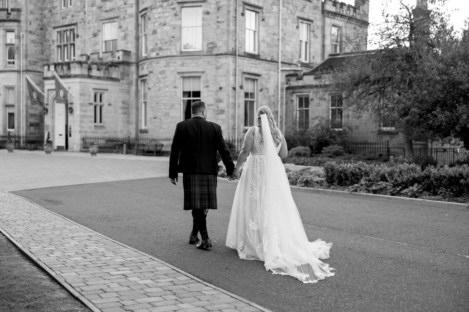Wedding photographs taken outside a historic stone castle with beautiful architectural details at Crossbasket Castle in Scotland.