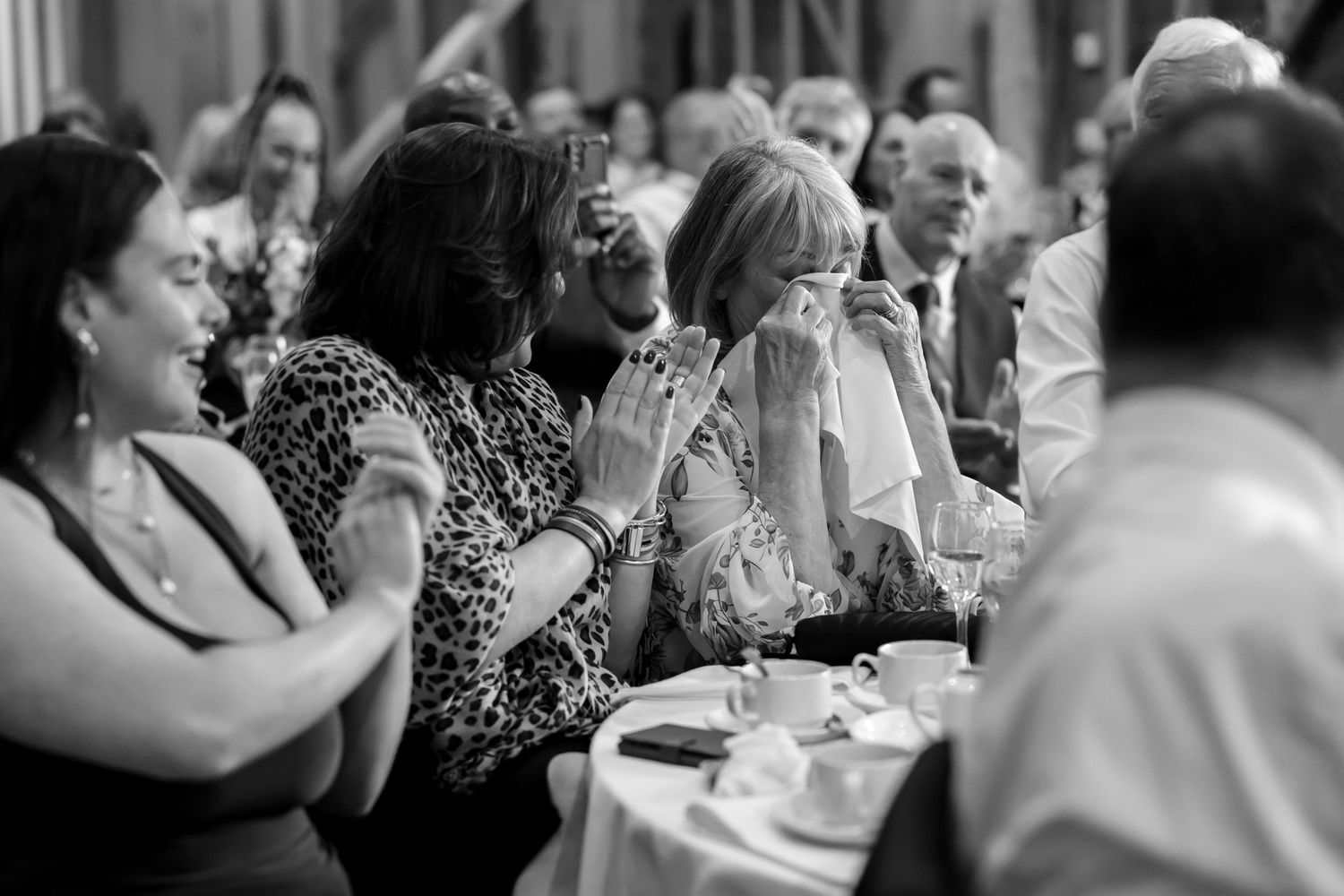 Wedding reception guests watching and celebrating during an emotional moment.