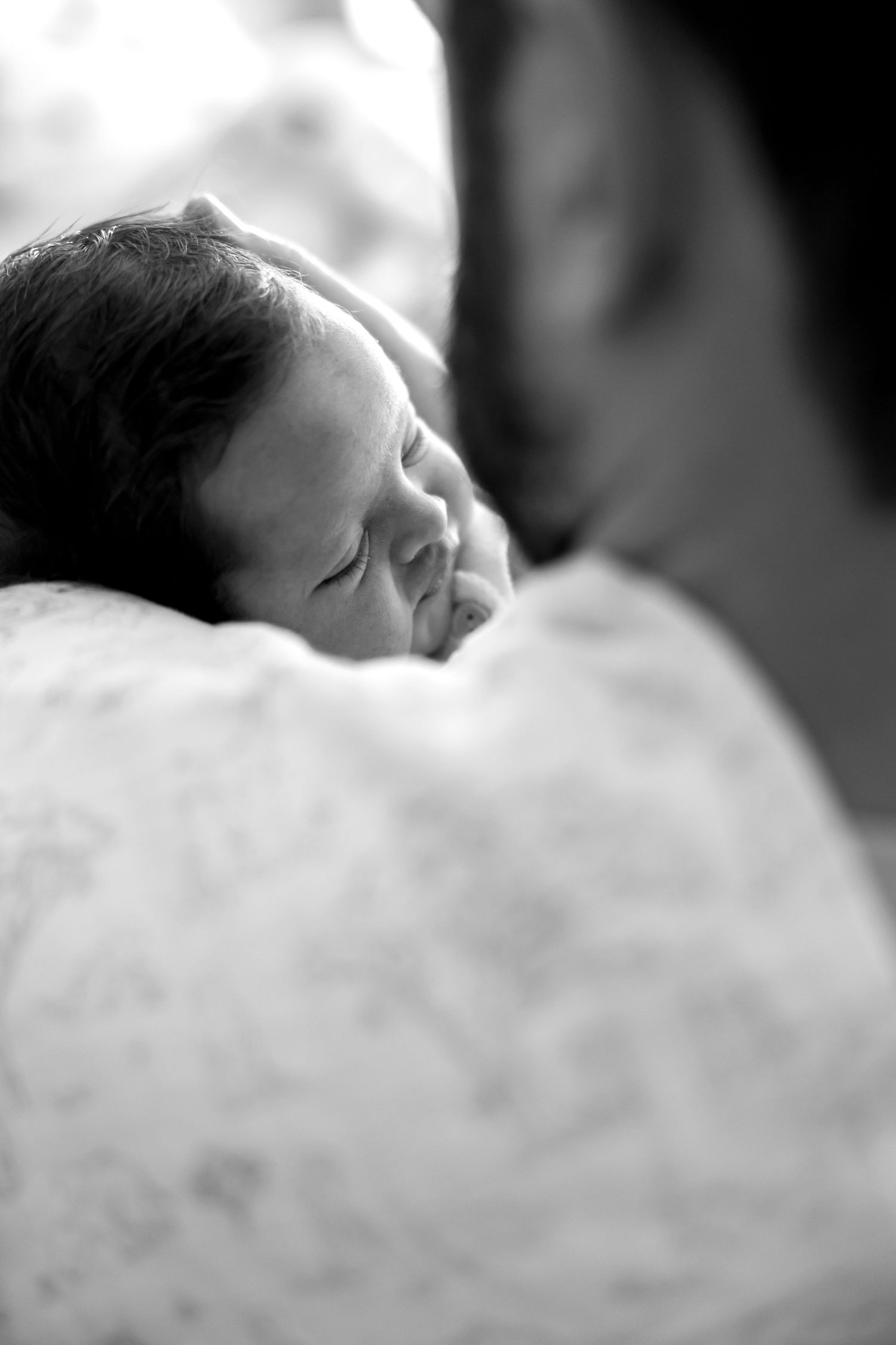 A black and white series of images showing a sleeping baby's profile in soft focus.