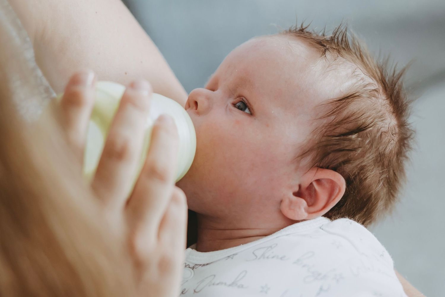 Baby drinking from a bottle in a series of close-up shots showing feeding from different angles.
