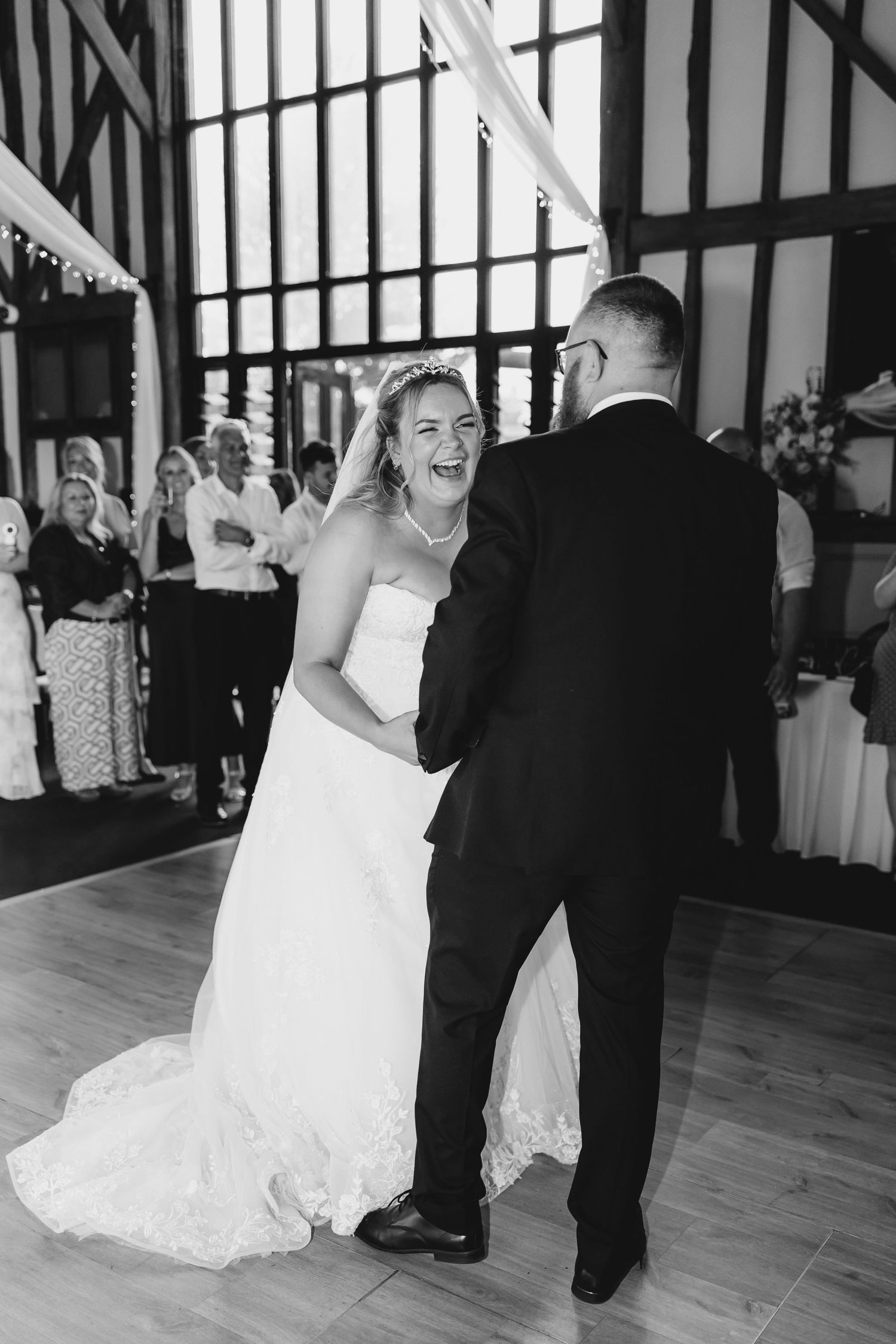 Dancing couple enjoying their first dance at a wedding reception in a timber-framed venue at Essendon Golf Club, Hertfordshire.