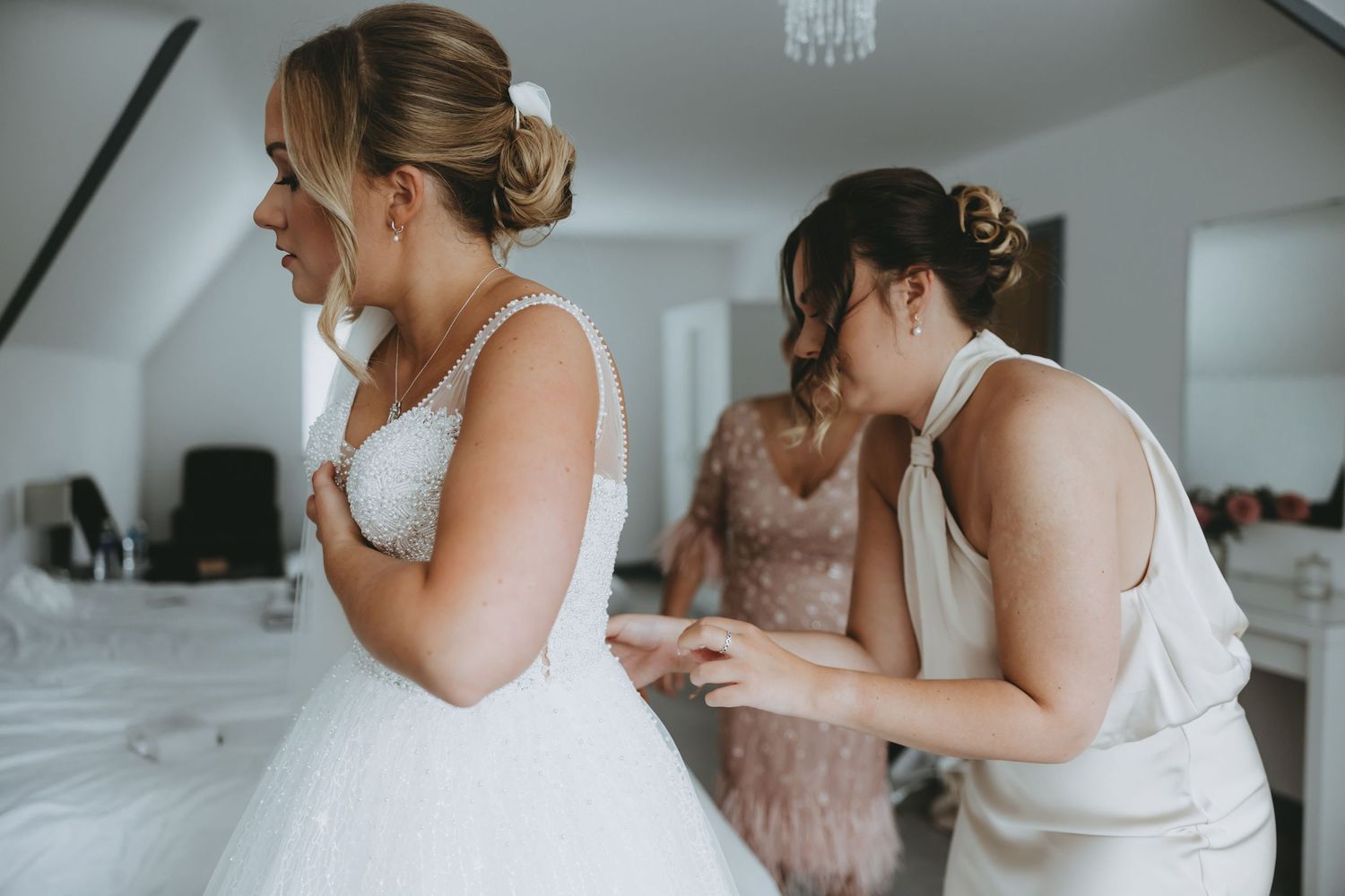 Wedding morning preparation scene in a bright indoor space with natural window light.
