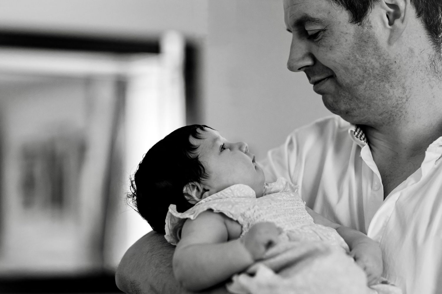 Black and white collage of intimate parent and newborn baby moments in hospital and home settings.