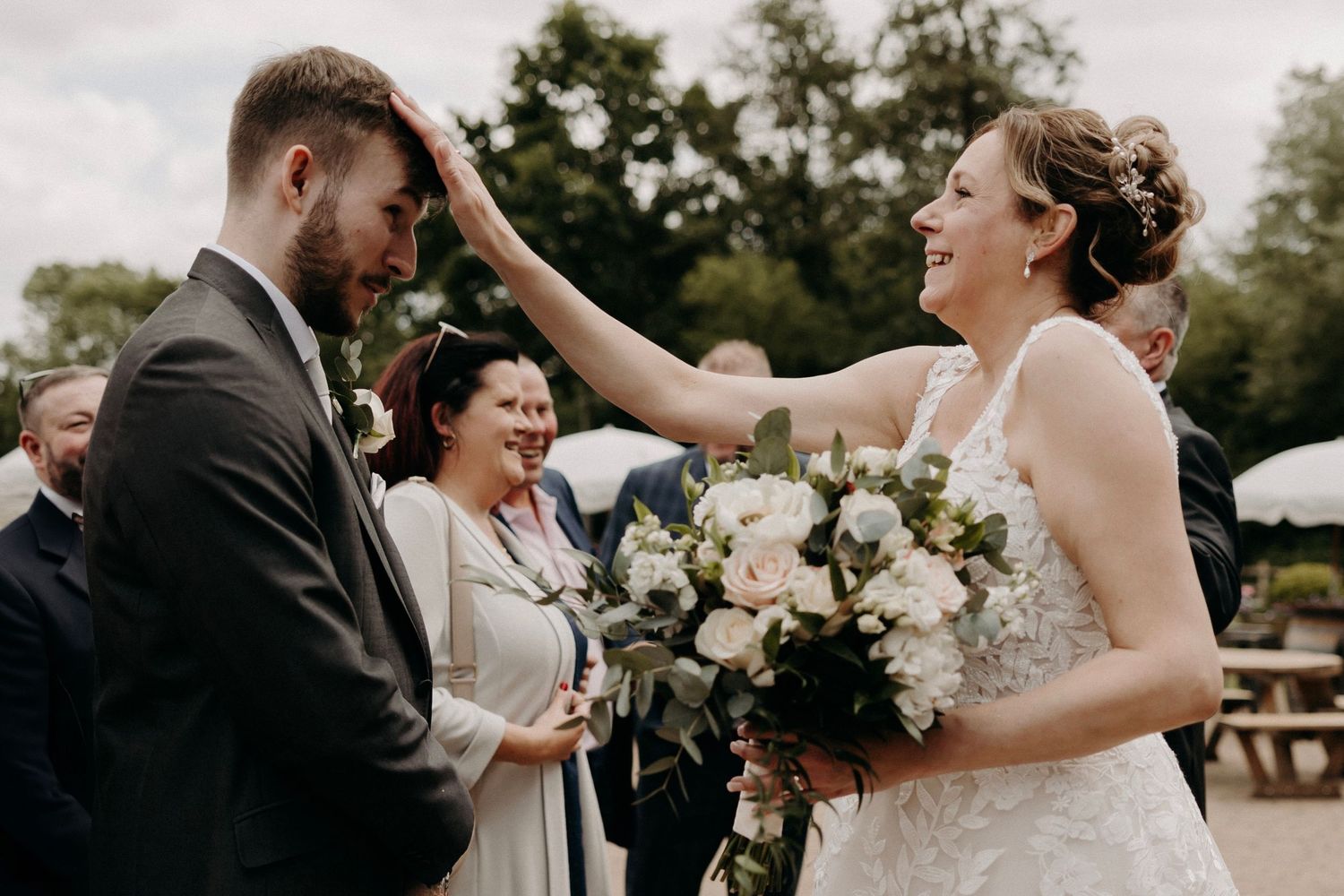 A series of candid wedding celebration moments captured in black and white showing joyful interactions outdoors.