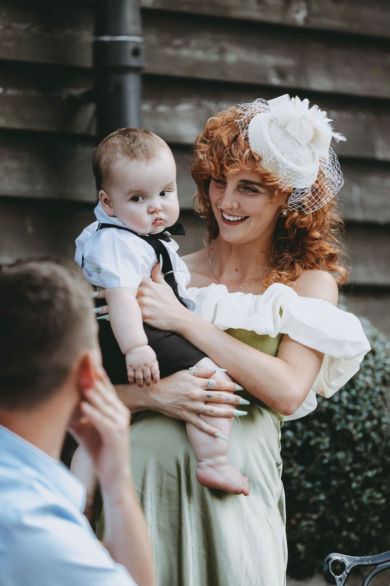 Sweet interaction between a child and woman in vintage-style dress at an outdoor gathering.