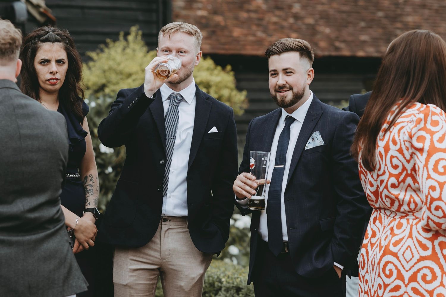 Wedding attendees enjoying drinks and conversation at an outdoor garden party.