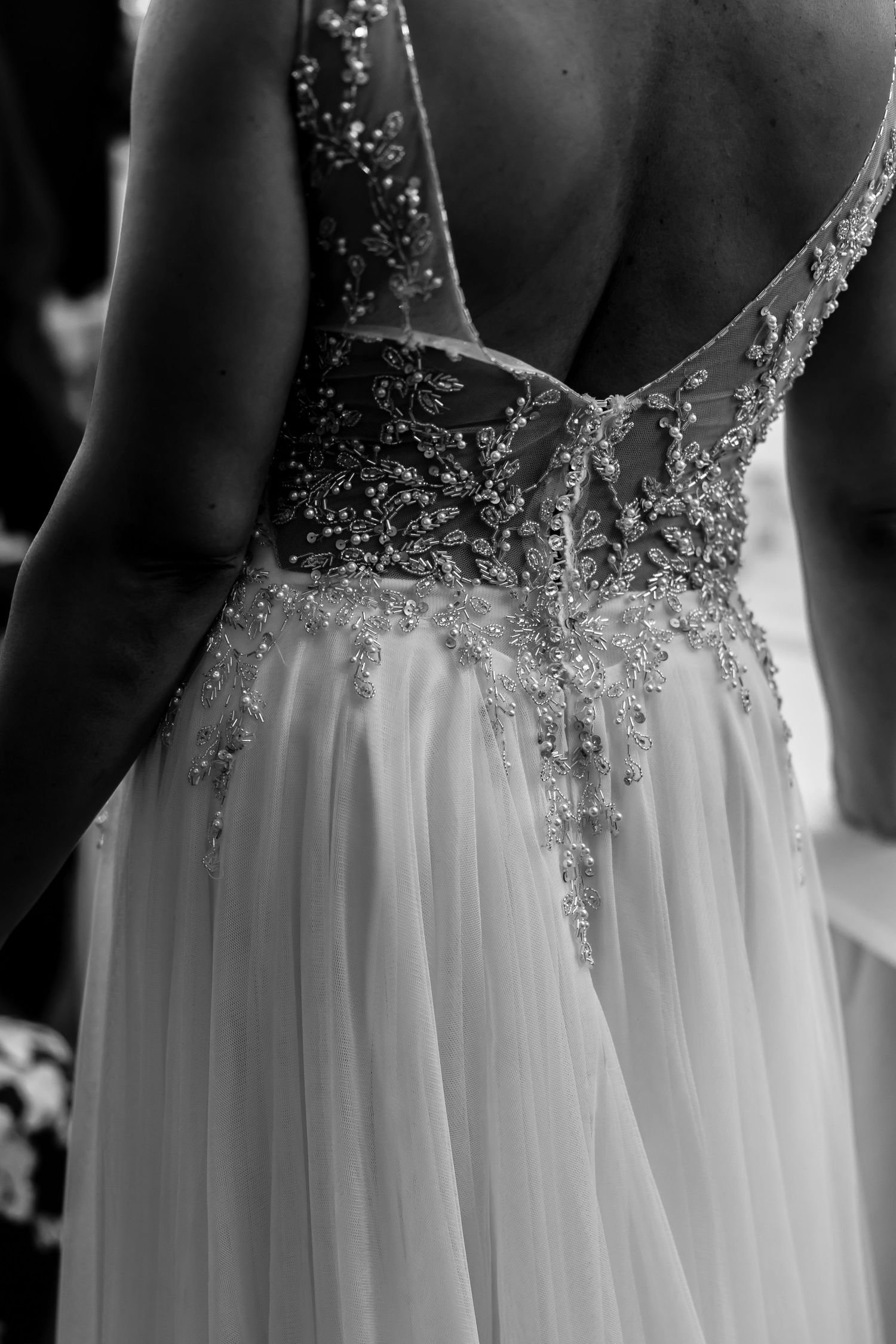 Close-up detail of sparkly beaded wedding dress bodice and flowing tulle skirt.