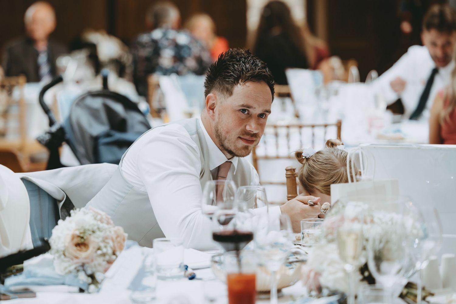 Wedding reception guests mingling at elegantly decorated dining tables.