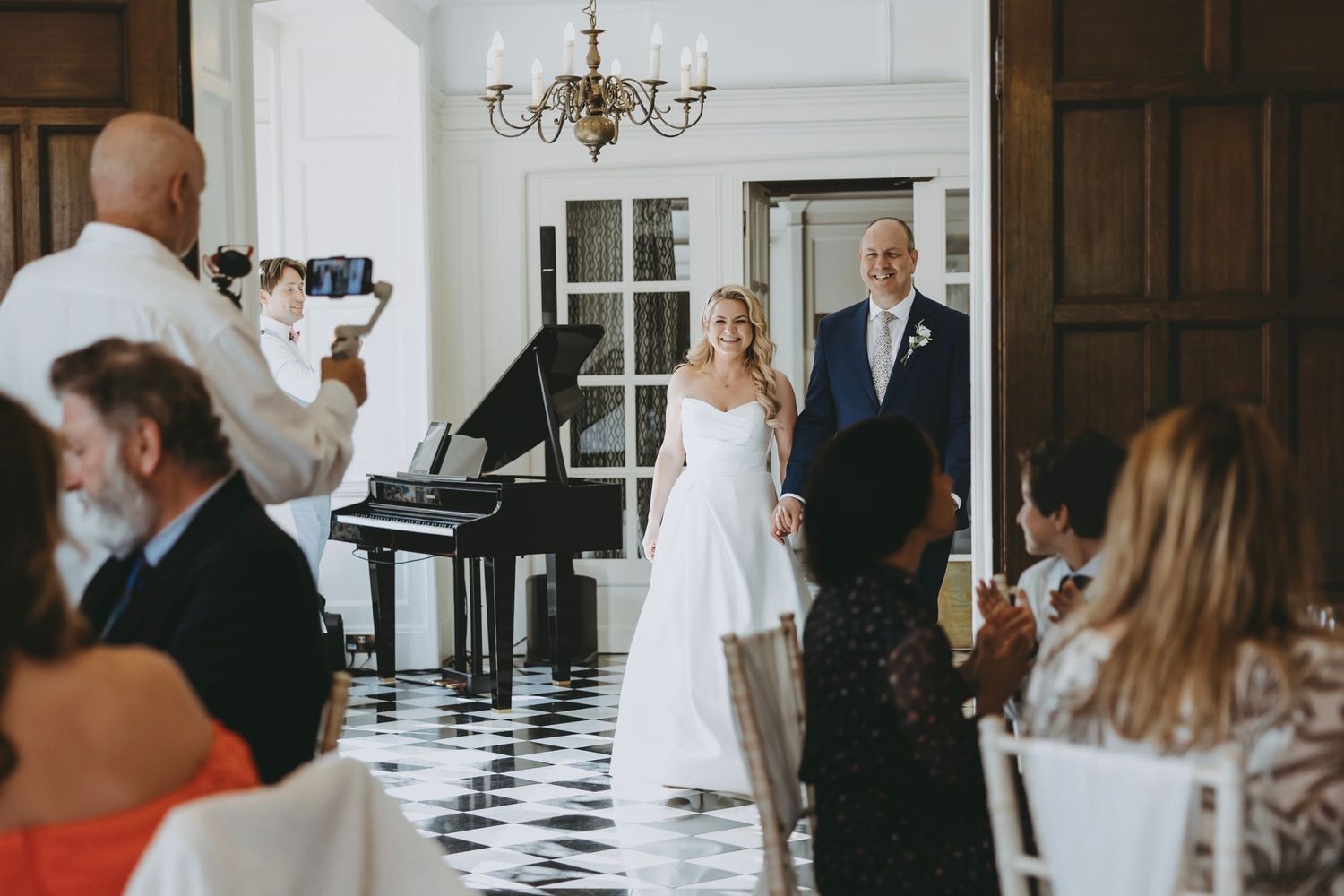 Wedding reception in an elegant hall with black and white checkered floors.