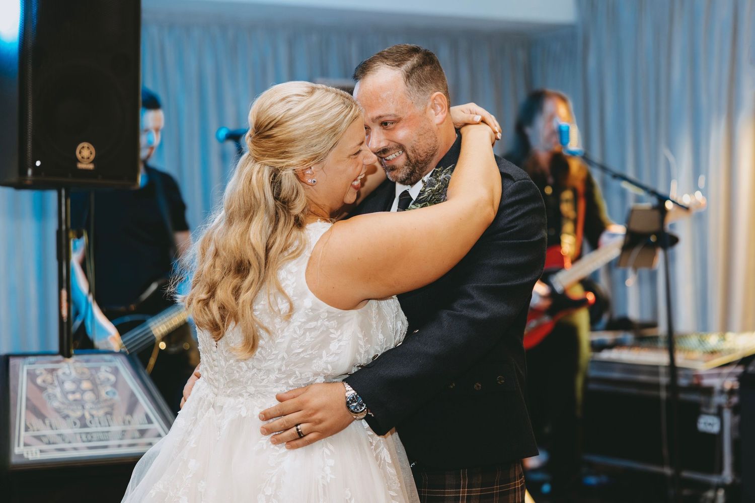 A couple shares a romantic slow dance at their wedding reception.